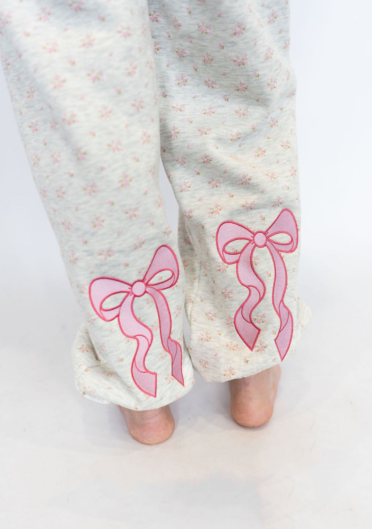Light heather grey base with soft pink floral pattern
Embroidered pink bows near the ankles for a feminine touch
Elastic waistband with drawstring for adjustable comfort
Relaxed jogger fit with elastic cuffs
Cozy fleece-lined interior
Matching hoodie available for the full sweet set
Available in sizes XS–XXL