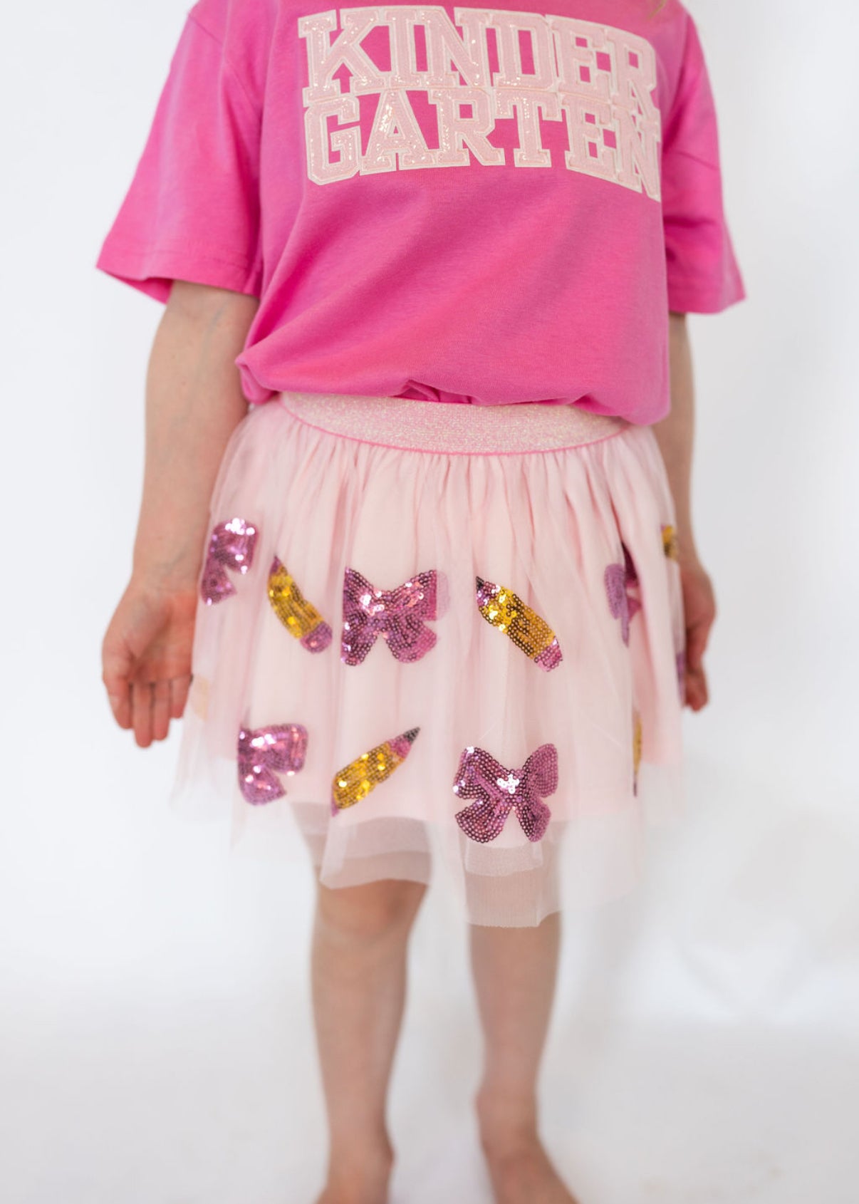 Details:
Light pink tulle overlay with pink bow and gold pencil sequin appliqués
Soft elastic waistband for a comfortable fit
Fully lined so it’s never itchy
Twirl-approved design for everyday wear or special school occasions
Perfect for pairing with back-to-school tees or sweaters