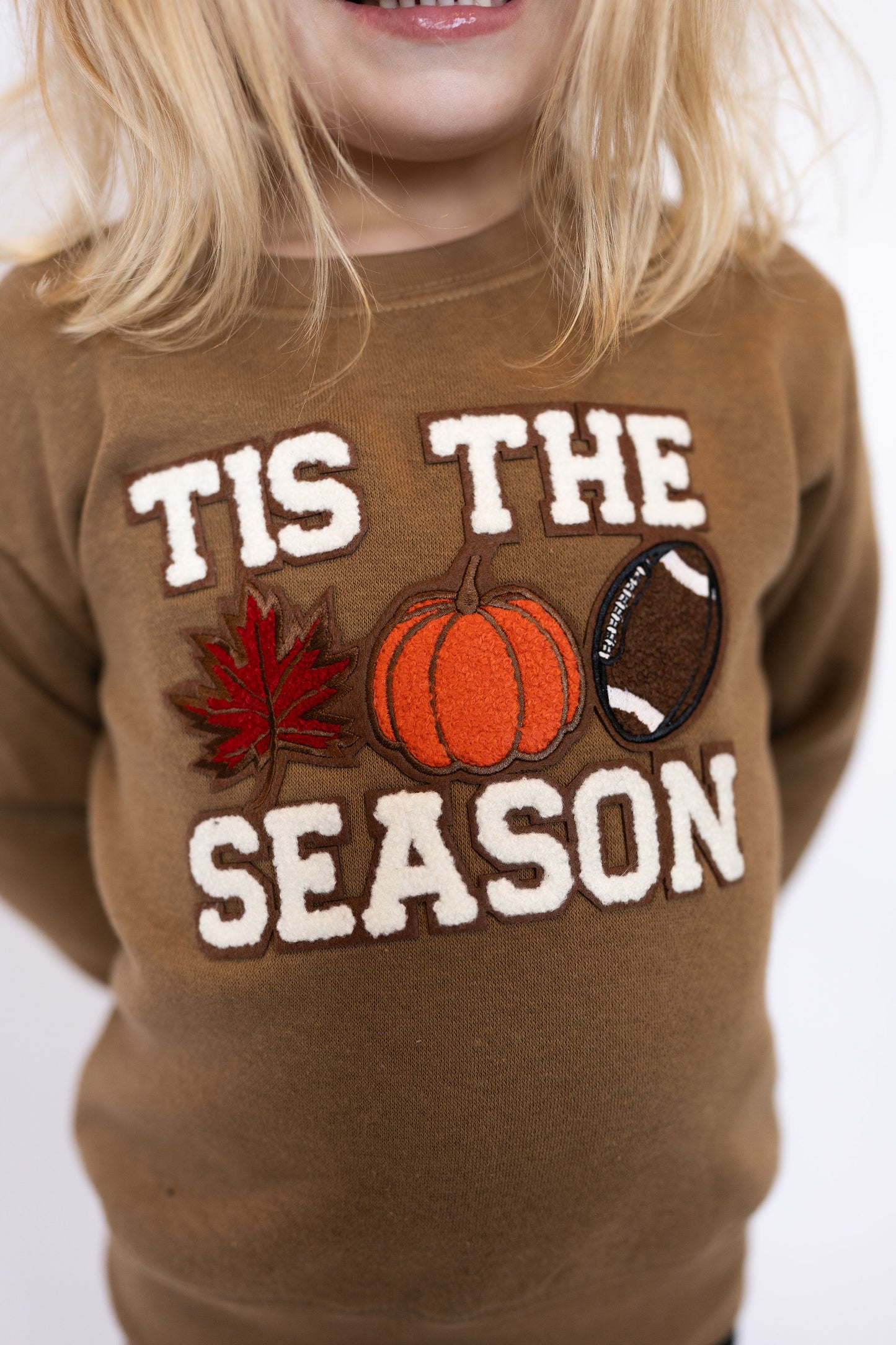 Brown crewneck with white “’TIS THE SEASON” lettering
Chenille patch accents: red maple leaf, orange pumpkin, brown football
Soft + cozy fabric perfect for cooler weather
Unisex fit, easy to style with jeans or leggings
Sizes: Toddler – Youth