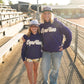 💜 Details:

Classic pullover hoodie in rich purple
Oversized white chenille “Huskies” patch front and center
Cozy fleece-lined interior for maximum comfort
Ribbed cuffs and hem + kangaroo pocket for all the essentials
Unisex fit (runs true to size for a relaxed look)
Available in Adult sizes S–XL
📣 Whether you're on the sidelines or running the snack shack, do it in Huskies style.