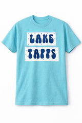 Adult baby blue t-shirt with navy “Lake Tapps” bubble lettering inside white rectangular panels with small blue dot accents on a white background