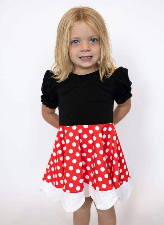 Classic red + white polka dot skirt with scalloped hem
Soft black puff sleeve top for a timeless look
Peekaboo bow detail on the back for extra charm
Built-in matching polka dot shorts for worry-free play and twirls
Stretchy, soft fabric perfect for all-day comfort
