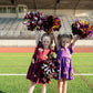 Ready, set, sparkle! This flutter-sleeve tiered dress brings the perfect mix of sweet and sporty to every game day. Whether she’s cheering from the sidelines or twirling through the tailgate, she’ll shine bright in every play.

🏈 Details:
Soft, stretchy cotton knit fabric for all-day comfort
Covered in sequin football appliqués (yes, they sparkle in the sun!)
Adorable flutter sleeves and a tiered skirt made for twirling
Available in Maroon and Purple to rep her favorite team
Sizes 2T through 7/8

