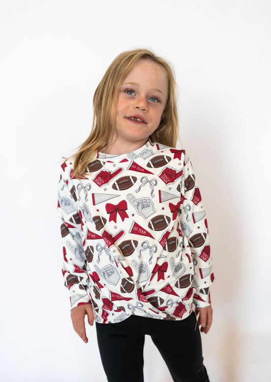 Details:

All-over maroon, silver, and white game day graphic print
Soft, stretchy athletic fabric for easy movement
Lightweight and breathable for all-day comfort
Stylish criss cross hem detail at the front
Ideal for spirit days, tailgates, and supporting your team in style
