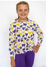 Details:

All-over purple, gold, and white game day graphic print

Soft, stretchy athletic fabric for comfort and movement

Long sleeves with a lightweight, breathable feel

Stylish criss cross hem detail for a flattering fit

Perfect for game days, pep rallies, or everyday spirited wear
