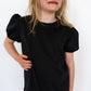 Classic black for effortless pairing

Scalloped hem for a subtle, girly flair

Short puff sleeves with elastic cuffs

Soft, stretchy fabric for all-day comfort

Works great with leggings, jeans, or skirts

Available in toddler &amp; youth sizes 2T–9/10