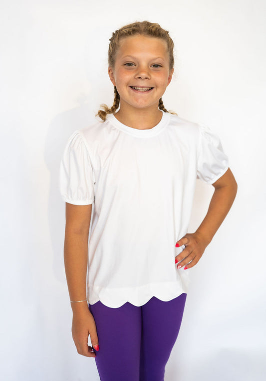 Crisp white color for a clean, classic look

Scalloped hem adds a playful, girly touch

Short puff sleeves with elastic cuffs

Soft, lightweight, and stretchy fabric for all-day comfort

Easy to pair with leggings, skirts, or denim

Available in toddler &amp; youth sizes 2T–9/10
