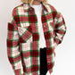 Person wearing a red and green plaid shirt over a white top on a white background