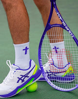 Tennis player with a racket and ball on a tennis court wearing Pathos Purple and White faith based performance socks