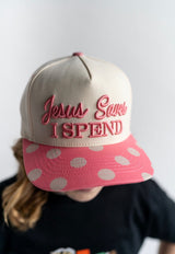 Jesus Saves I Spend embroidered women’s trucker hat with pink polka dot brim worn by woman
