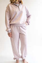 Woman in blush colored scuba set. Quarter Zip Top and Jogger bottoms in blush against a white background