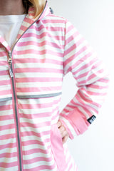 Lulu Mac Pink and white striped rain jacket worn by a women with a white background. 