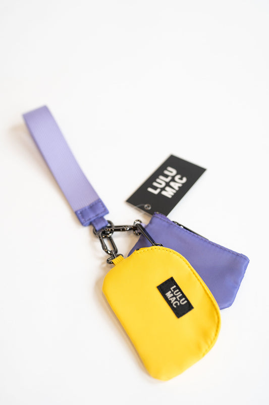 Yellow pouch and purple pouch with purple strap and Lulu Mac label on a white background