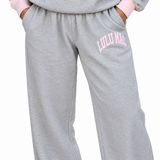Lulu Mac heather gray puff jogger pants with a light pink arched logo on the upper leg, featuring a relaxed fit, elastic waistband, side pockets, and cuffed ankles.