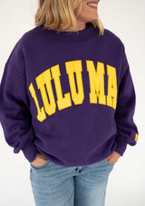 Women's Lulu Mac Purple/Yellow Stitch Sweatshirt featuring oversized yellow stitched LULU MAC lettering across the chest, a relaxed fit, dropped shoulders, and ribbed cuffs, styled with light-wash jeans.
