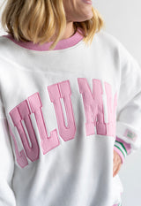 Close up pink varsity appliqué lettering on Lulu Mac white social club crewneck  sweatshirt