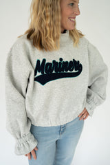 Women's heather gray Mariners varsity patch mock neck sweatshirt with oversized fit, elastic hem, and cozy long sleeves styled in a flat lay on a white background.
