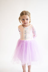 Young girl wearing a light pink dress with a floral bodice and purple tutu skirt on a white background. Mila and Rose, Tutu Dress, Spring, Floral, Easter