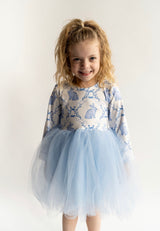 Young girl wearing a  blue bunnies floral dress with a blue tulle skirt on a white background