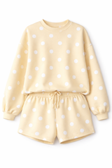 Yellow polka dot lounge set with long sleeve top and drawstring shorts on a white background with soft shadows