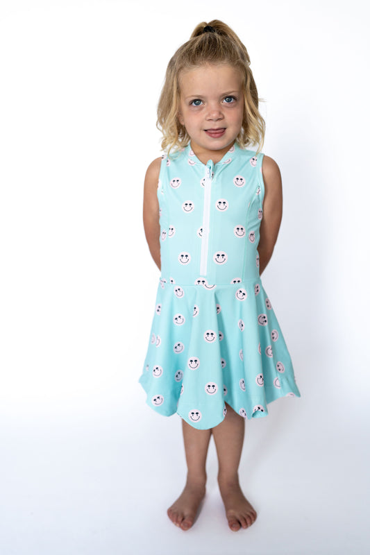 Sporty, sweet, and made for twirling—this athleisure dress brings all the joy! With a cheerful pink smiley face print on the happiest aqua blue, your little sunshine will be grinning from playground to playdate.