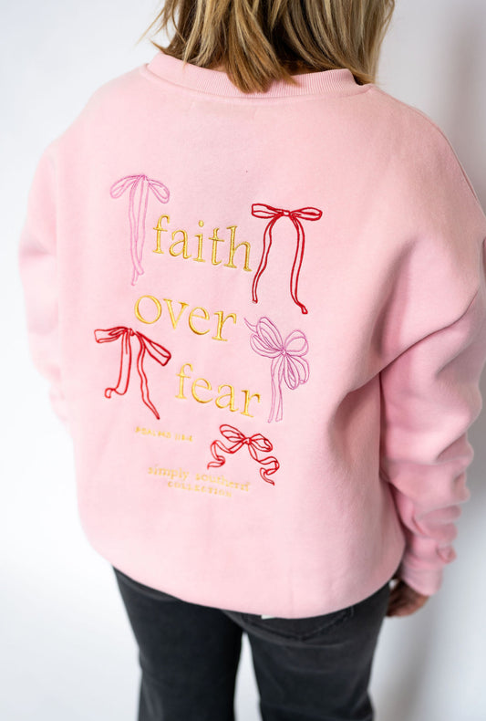 Soft pink crewneck sweatshirt
Front: small embroidered bow detail
Back: “Faith Over Fear” embroidery with bow accents + Psalm 118:6
Relaxed, unisex-inspired fit for all-day comfort
Cozy cotton blend
Women’s sizes XS–XXL