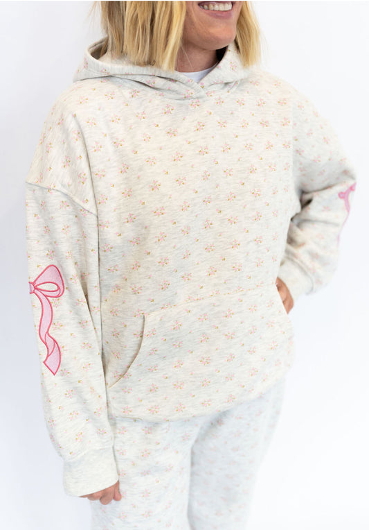 Light heather grey base with tiny pink floral print
Embroidered pink bows on sleeves 🎀
Soft fleece interior for all-day comfort
Front kangaroo pocket
Relaxed, slightly oversized fit
Matching sweatpants available for the full set
Available in sizes XS–XXL