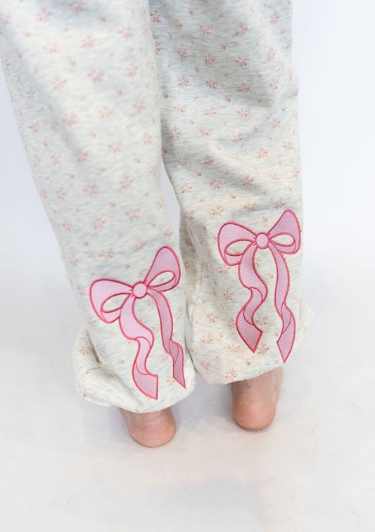 Light heather grey base with soft pink floral pattern
Embroidered pink bows near the ankles for a feminine touch
Elastic waistband with drawstring for adjustable comfort
Relaxed jogger fit with elastic cuffs
Cozy fleece-lined interior
Matching hoodie available for the full sweet set
Available in sizes XS–XXL