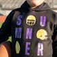 Details:

Black sweatshirt with purple + gold distressed-style graphic
Features helmets, football, and lettered "SUMNER" design
Soft fleece-lined interior for ultimate coziness
Ribbed cuffs and waistband for a comfy fit
Available in Toddler & Youth sizes