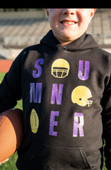 Details:

Black sweatshirt with purple + gold distressed-style graphic
Features helmets, football, and lettered "SUMNER" design
Soft fleece-lined interior for ultimate coziness
Ribbed cuffs and waistband for a comfy fit
Available in Toddler & Youth sizes