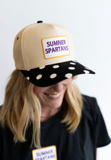 Person wearing a beige cap with a 'Summer Spartans' patch on a white background
