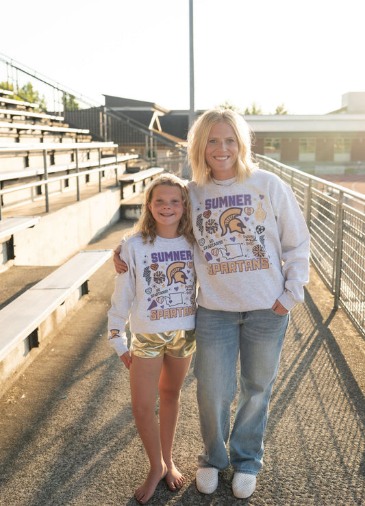 💜 Details:

Light heather gray fleece crewneck

Bold graphic with Sumner Spartan mascot, cheer icons, and playful doodles

Unisex fit – true to size for a comfy, relaxed feel

Available in sizes S–XL
