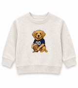 Sweet Wink Toddler heather oatmeal crewneck sweatshirt featuring an adorable golden retriever puppy wearing a navy football jersey and holding a football on a clean white background.
