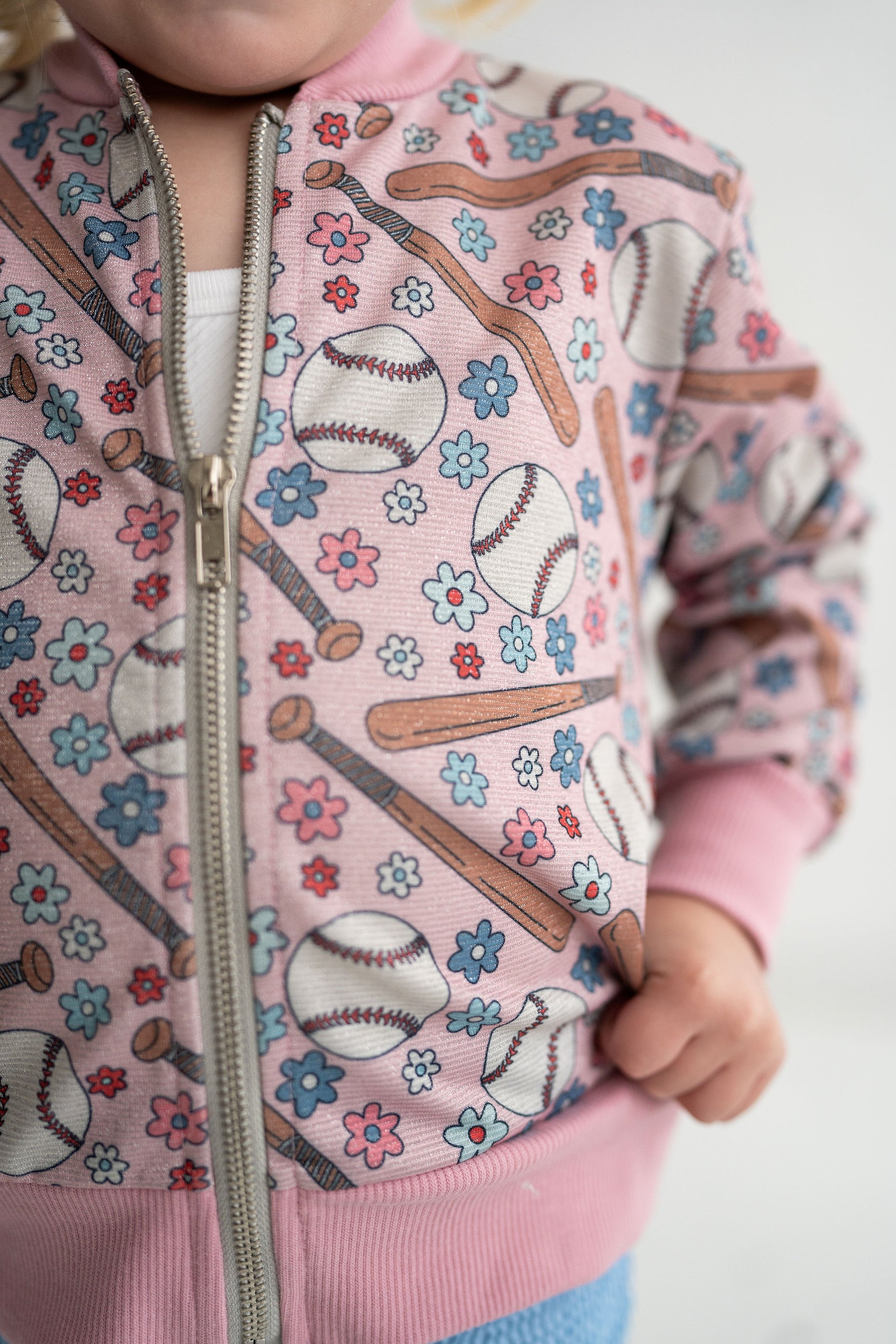 Adorable, lightweight, baseball jacket with flowers, baseball bats and baseballs. Jacket covered in a shimmer fabric. 