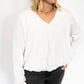 Lightweight + breathable fabric
Relaxed fit with a touch of shape at the waist
Bubble hemline for a modern twist
Flattering v-neck cut – perfect for layering or styling solo
Available in sizes S–XL