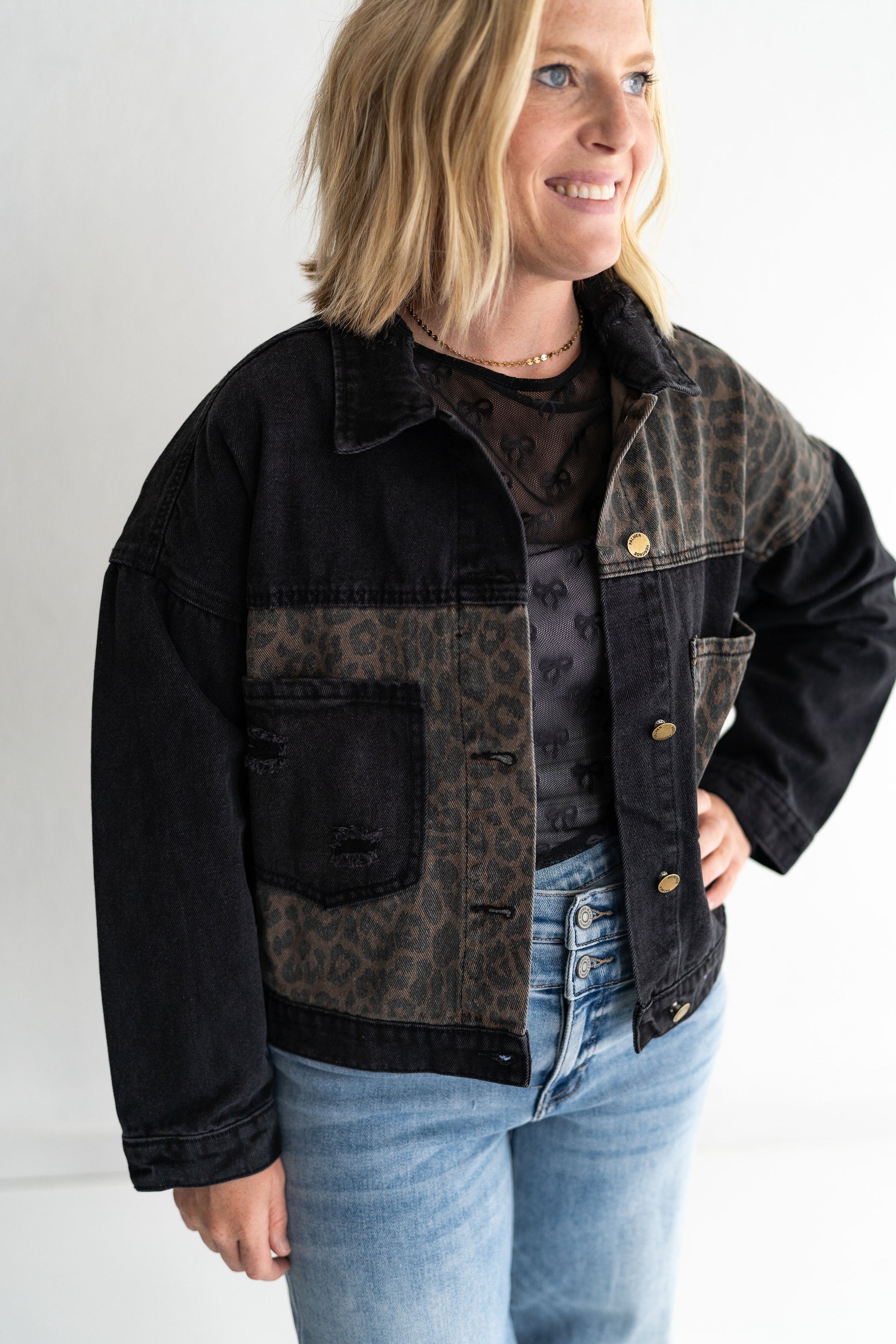 Classic black denim with a twist, Leopard print paneling for that fierce, fashion-forward edge,Two oversized chest pockets for utility + style, Relaxed fit and full button front, 65% Cotton | 35% Polyester