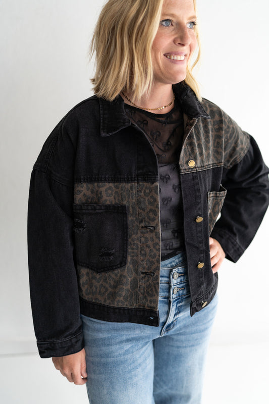 Classic black denim with a twist, Leopard print paneling for that fierce, fashion-forward edge,Two oversized chest pockets for utility + style, Relaxed fit and full button front, 65% Cotton | 35% Polyester