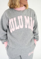 Close-up of the Lulu Mac Puff Mock Neck Sweatshirt in heather gray, showcasing oversized light pink LULU MAC lettering, a contrasting pink ribbed mock neck, dropped shoulders, and a relaxed, oversized silhouette.