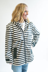 Woman wearing a Lulu Mac Darby Rain Coat in black and white striped jacket against a white background. 