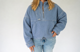 Veveret Seaside Stripe Quarter Zip in washed blue and white pinstripes with a high collar, front pocket, relaxed fit, and adjustable drawstring hem.