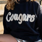 Absolutely! Here’s a Shopify description for the youth version of the navy Cougar hoodie in sizes S–L:

---

**Youth Cougar Spirit Hoodie – Navy Fleece**
Let your little Cougar fan cozy up in team pride! This youth-sized navy hoodie is soft, sporty, and full of school spirit—perfect for chilly bleachers, spirit week, or just repping their favorite team with big kid energy.

🐾 **Details:**

* Navy pullover with soft fleece lining
* White chenille *Cougars* patch across the chest
* Classic kangaroo pocket 