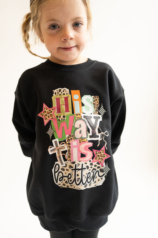 Child wearing a black sweatshirt with colorful text design on a white background
