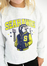 Youth heather gray Seahawks spirit crewneck featuring bright green Seahawks lettering and a navy and green hawk mascot in a varsity jacket.