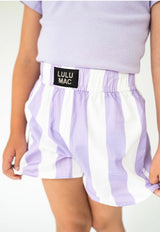 A child wearing lavender and white vertically striped shorts with a black waistband label that reads 'LULU MAC'.